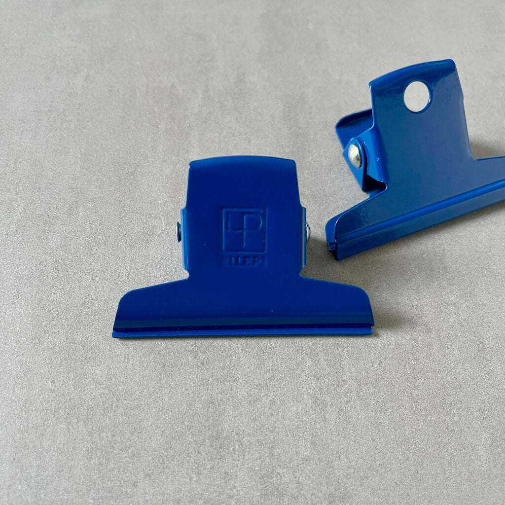 Two blue clips by Ellepi on a gray background