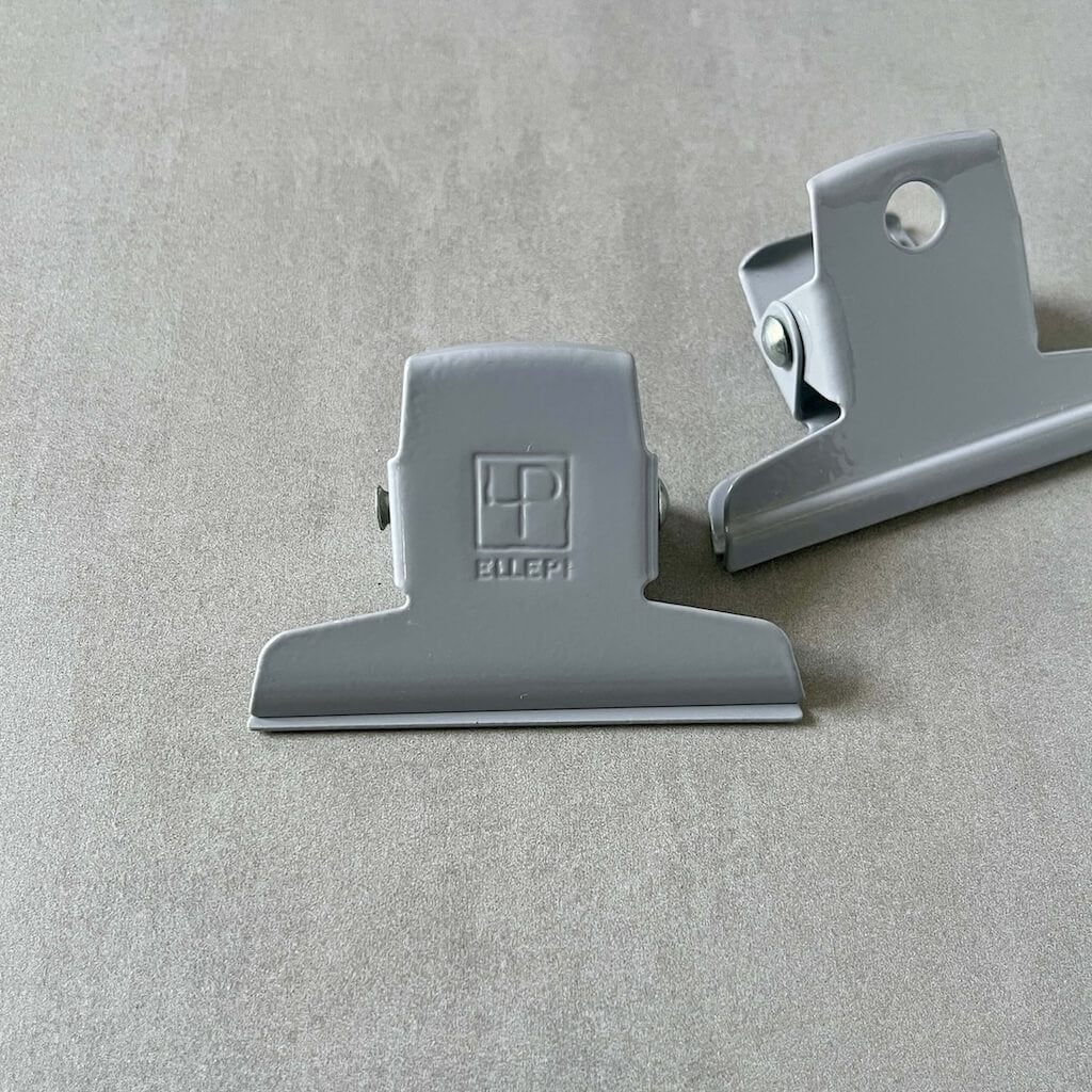 Two gray clips by Ellepi on a gray background