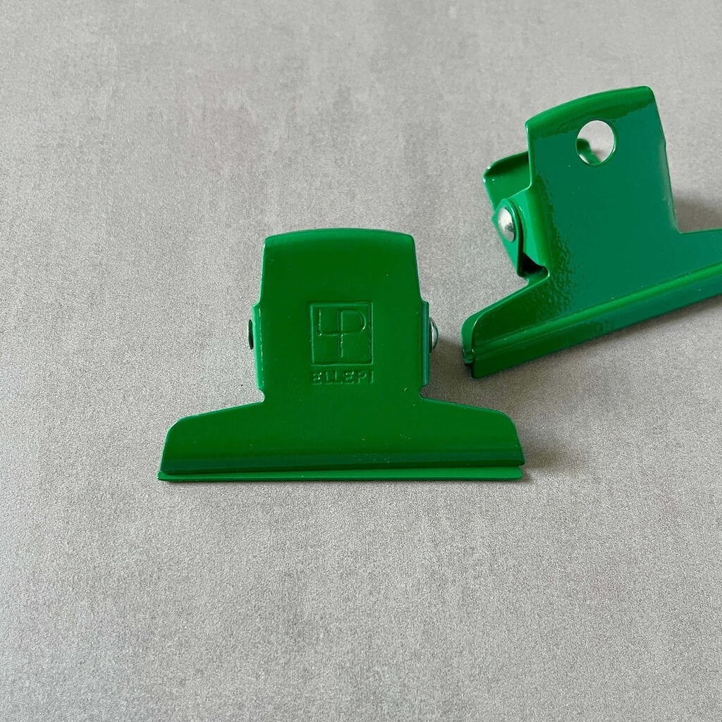 Two green clips by Ellepi on a gray background