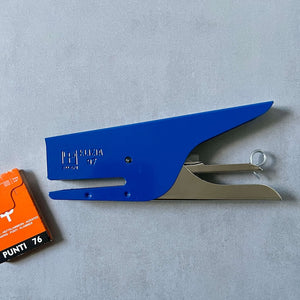 Blue stapler with a small box of staples on a gray background