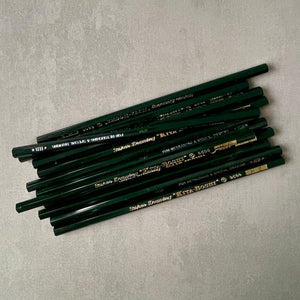 Stack of green pencils with gold 'Kita-Boshi' branding on a gray surface