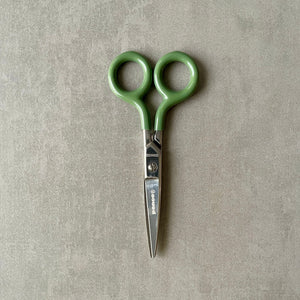 Green-handled scissors with 'Penco' brand on a gray background