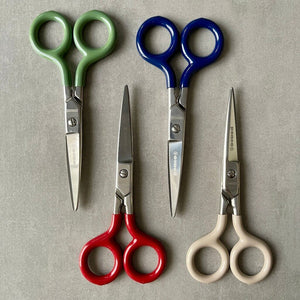 Four pairs of scissors with colored handles and 'Penco' brand on a gray background
