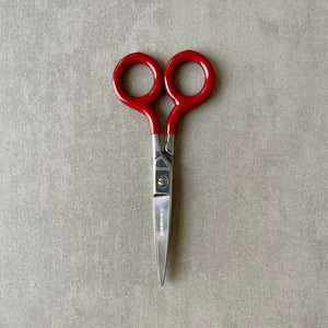Red-handled scissors on a gray background