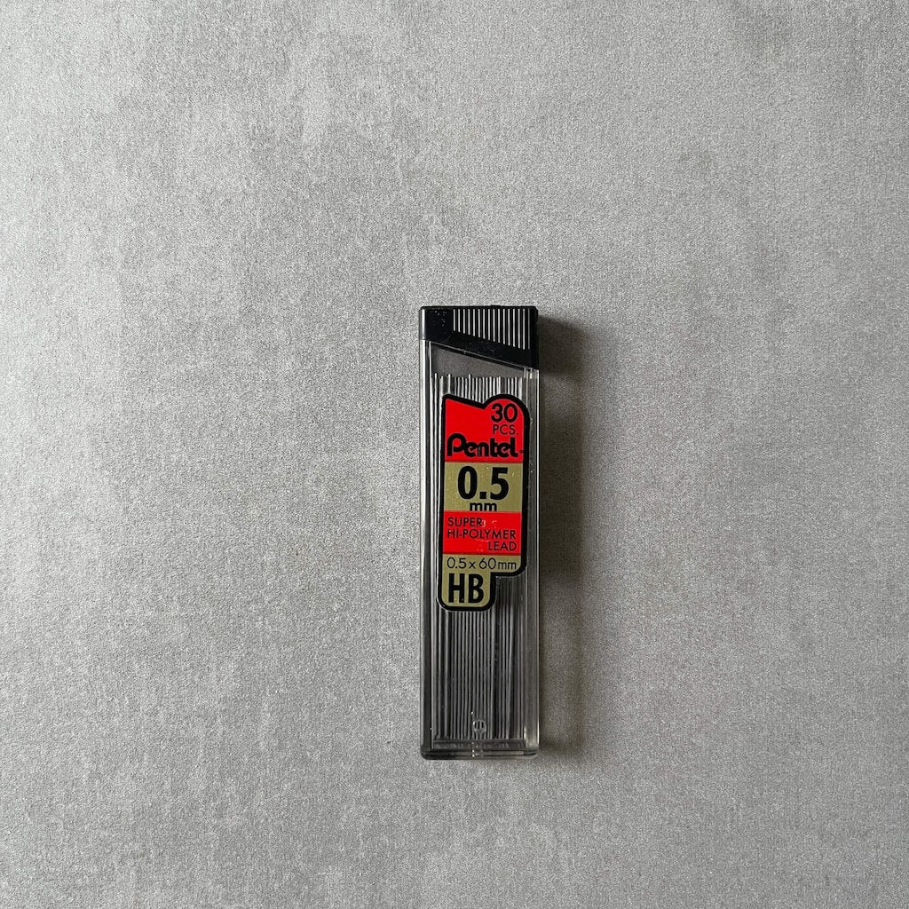 Pentel 0.5mm pencil lead refills in holder with black top on a gray background