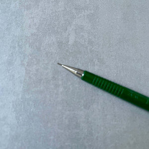 Green pen with a metallic tip on a gray textured background