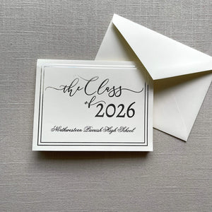 Graduation announcement card with silver foil design for 'the Class of 2026' and an envelope on a gray textured background.