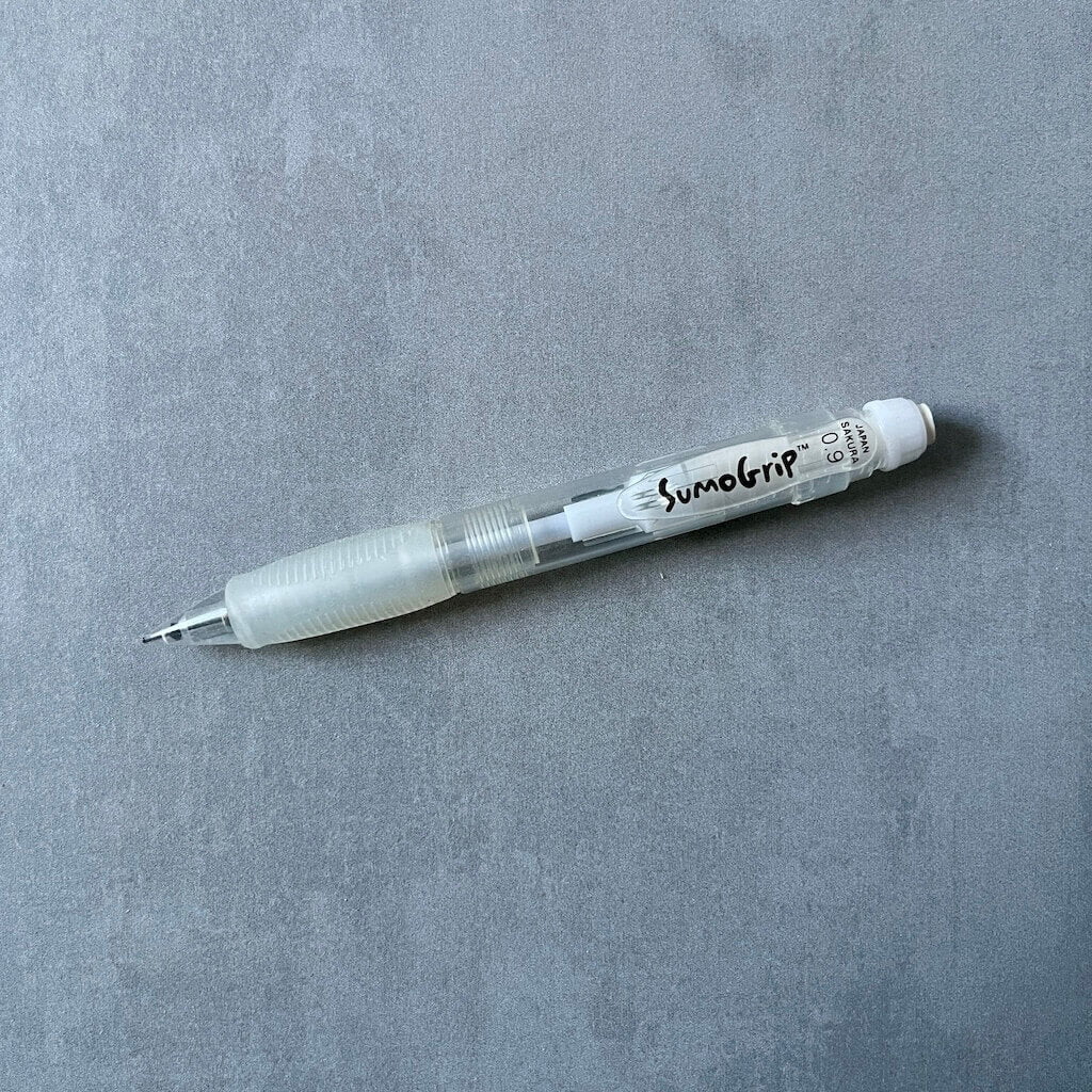 SumoGrip brand 0.9 mm white mechanical pencil on a gray background